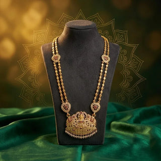 Gold-coloured Impon haram (long necklace) on a black display bust