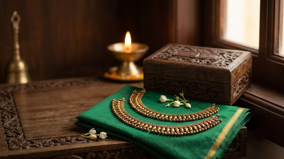 Pair of Impon kolusu (five-metal anklets) with mango charms and small bells on green silk saree fabric