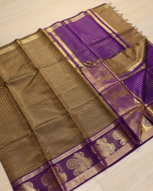 Premium Cotton Silk Saree With Blouse, folded purple fabric with gold-toned borders featuring six patterned motifs and horizontal lines