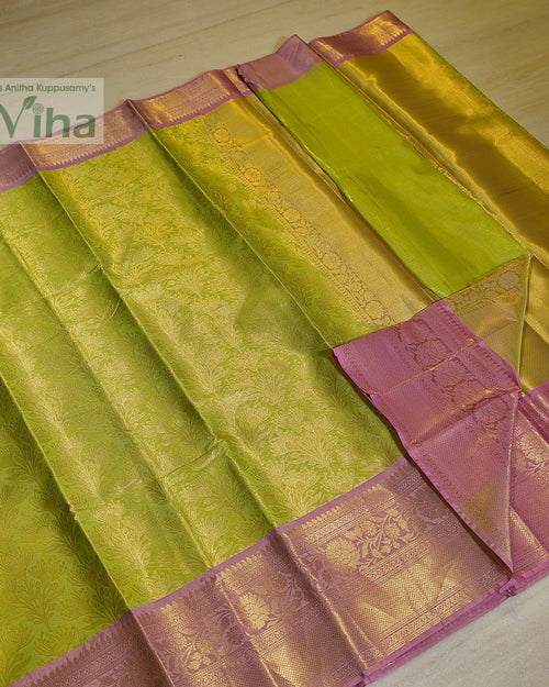 Premium Katan Silk Saree With Blouse, folded green and pink fabric with shiny gold-toned patterned borders and intricate floral motifs