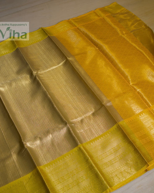 Premium Katan Silk Saree With Blouse, folded yellow and gold-toned fabric with glossy surface finish and patterned border bands