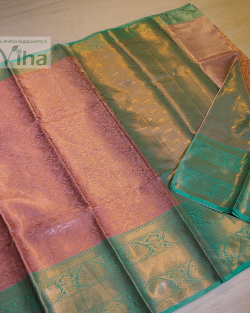 Premium Katan Silk Saree With Blouse, a folded pink and teal fabric featuring gold-toned woven paisley and floral patterns throughout
