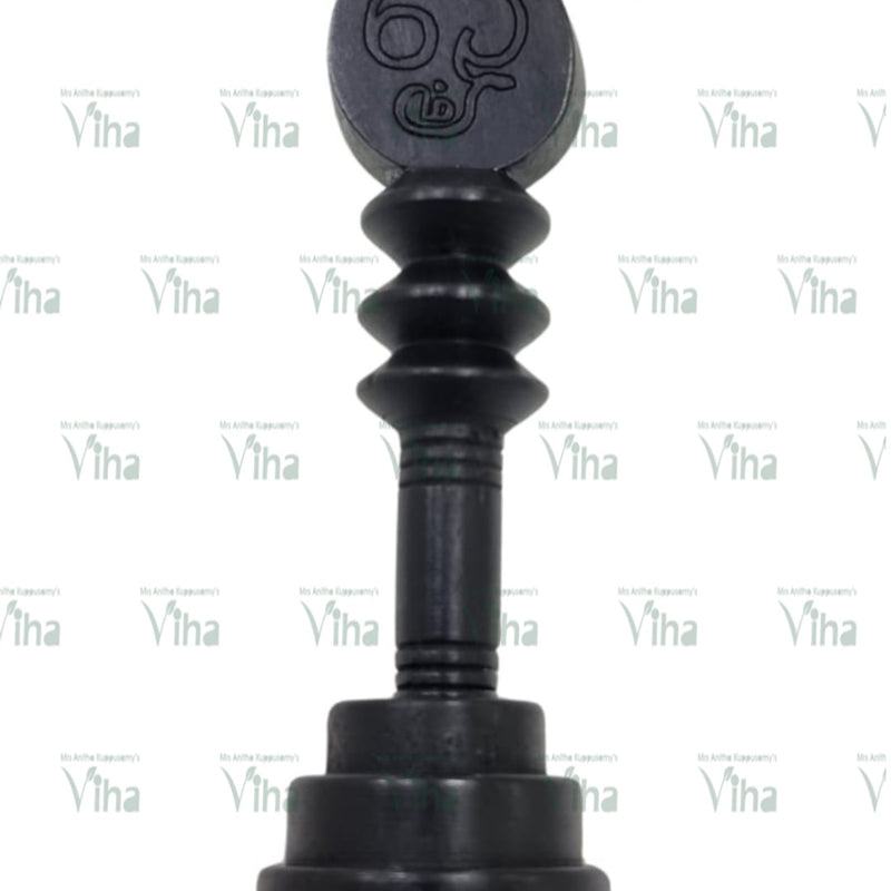 Karungali Wood Vel, a black piece with a pointed oval top carrying engraved symbols, three ribbed sections and a stepped round base
