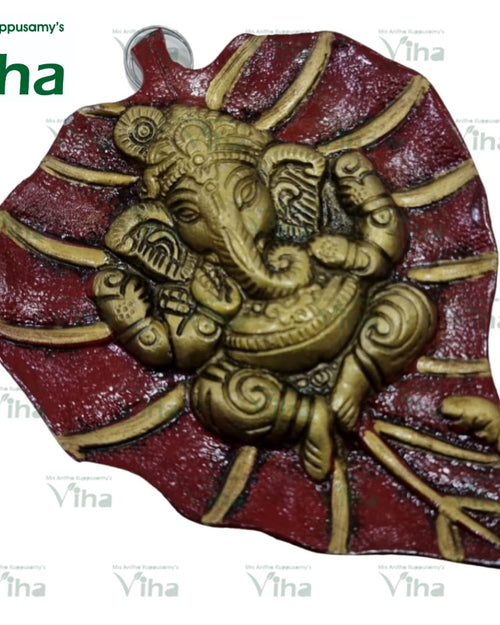 Leaf Ganesha Wall Hanger, a gold-toned relief figure on a red-and-gold leaf-shaped plaque with textured surface finish