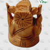 Wooden Ganesha, a brown-toned carved figure featuring a circular facial pattern with a central dot and diagonal grooves on the body and base