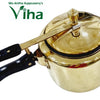 Brass-toned pressure cooker with black handles and a gold pressure valve