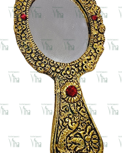 Hand Mirror, a gold-toned hand mirror featuring an oval glass pane and ornate embossed handle with four red circular stones