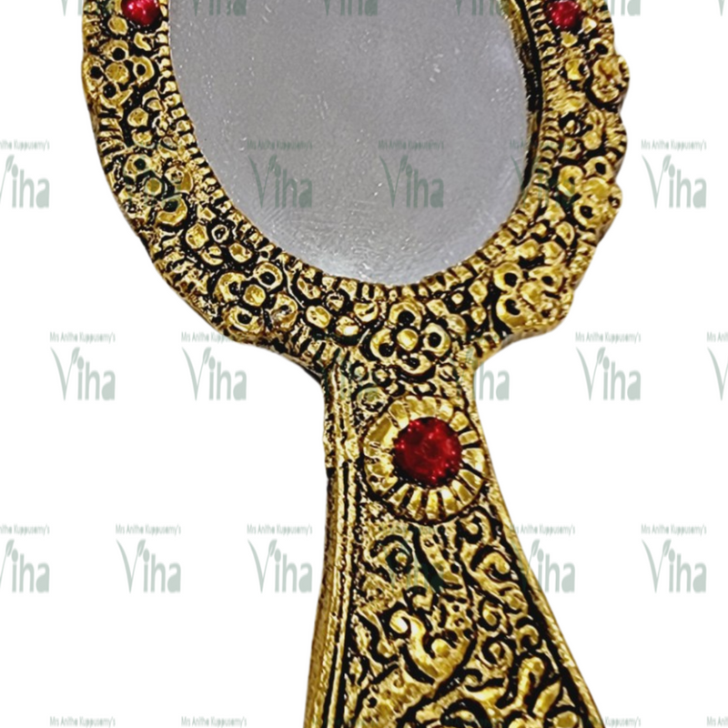 Hand Mirror, a gold-toned hand mirror featuring an oval glass pane and ornate embossed handle with four red circular stones