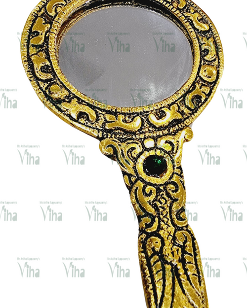 Hand Mirror, a hand mirror with a gold-toned frame featuring embossed patterns and one green circular stone inset on the handle