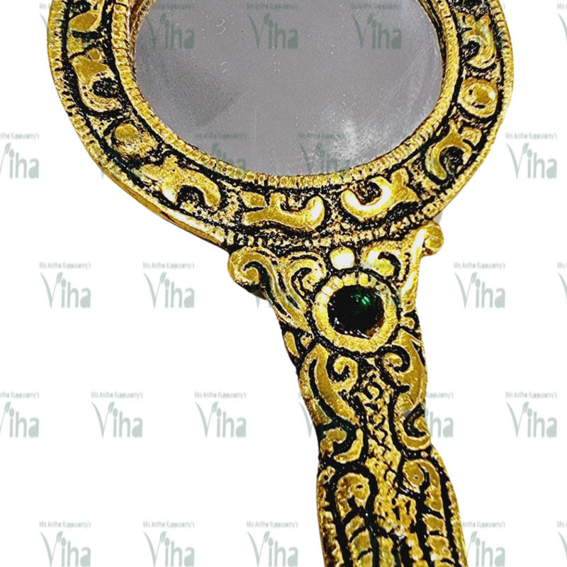 Hand Mirror, a hand mirror with a gold-toned frame featuring embossed patterns and one green circular stone inset on the handle