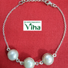 Pearl Bracelet Silver, a silver-toned link bracelet with three round white beads and a lobster clasp on red fabric
