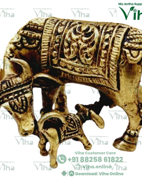 Cow and calf in brass, cow under a panelled blanket with the head lowered and a calf standing under the belly