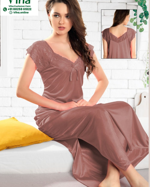 Nighty Free, a woman wearing a mauve dress with V-neckline and cap sleeves sits on a bed next to a yellow pillow