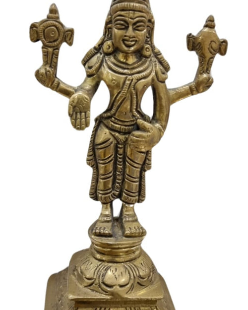Perumal in brass, four-armed figure standing on a tiered rectangular pedestal with a discus and conch raised