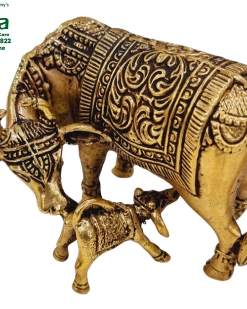 Cow and calf in brass, the cow under an ornately patterned blanket with the head lowered to a calf beneath