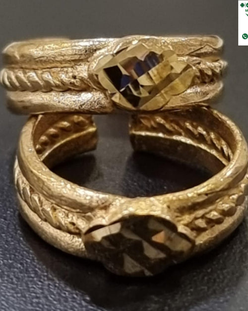 Impon Toe Ring, two gold-toned textured rings with braided details and a central faceted stone are stacked vertically on a dark surface