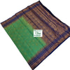 Soft Silk Saree With Blouse, a folded green fabric with blue and gold-toned borders and patterned panels featuring large circular motifs