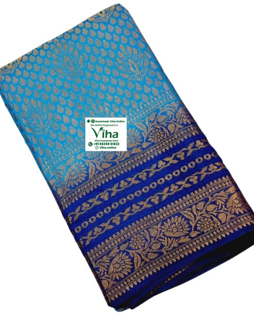 Soft Silk Saree With Blouse, a blue folded fabric with gold-toned patterns featuring leaf motifs and floral borders