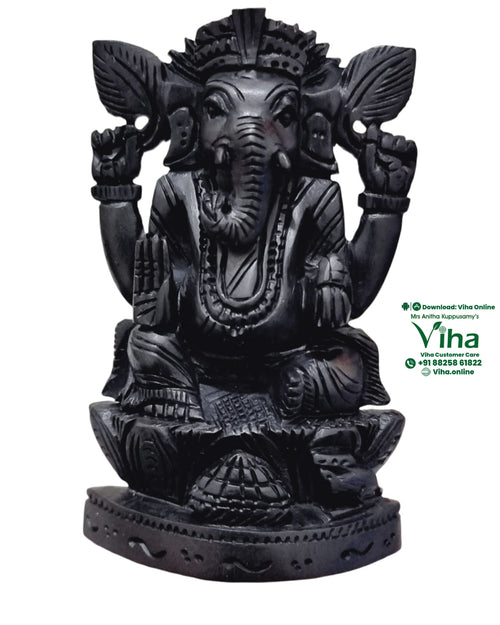Karungali Ganesha, seated four-armed elephant-headed figure carved in black karungali wood, trunk curved to a bowl