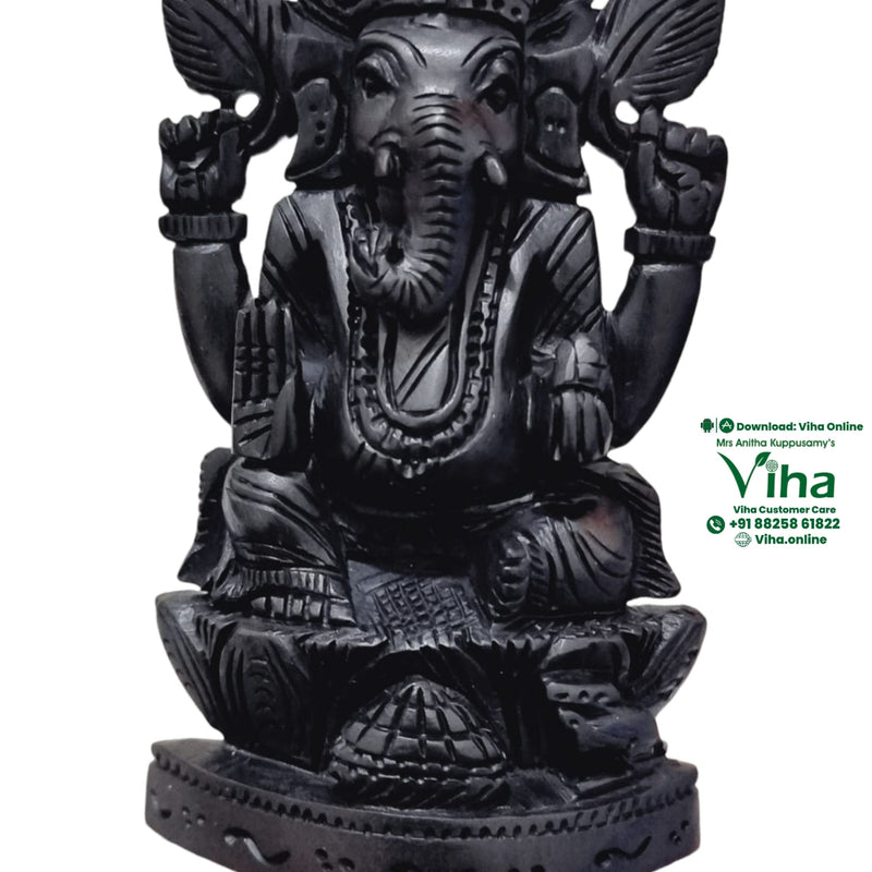 Karungali Ganesha, seated four-armed elephant-headed figure carved in black karungali wood, trunk curved to a bowl