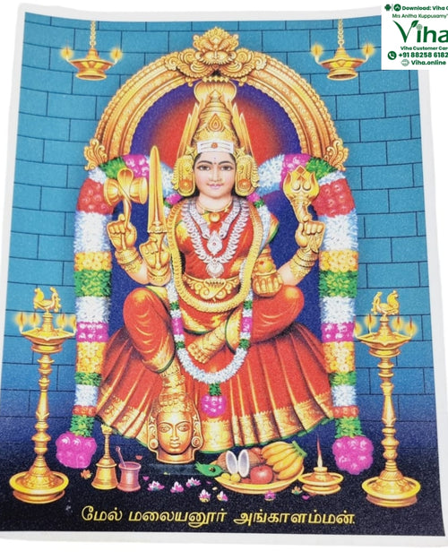 Mel Malayanoor Angalaparameshwari Photo - Big, a glossy print of a central figure flanked by two tall gold-toned lamps against a blue brick wall