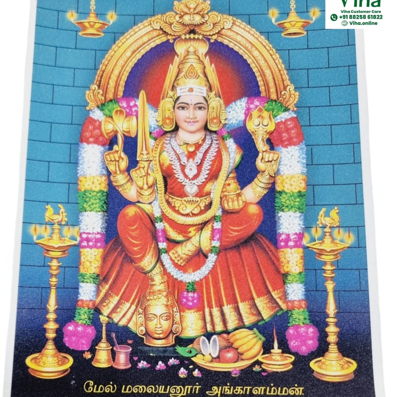 Mel Malayanoor Angalaparameshwari Photo - Big, a glossy print of a central figure flanked by two tall gold-toned lamps against a blue brick wall