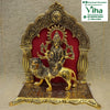 Durga Statue, a gold-toned metal figurine of a multi-armed figure on a lion, set inside an ornate, arched architectural structure against a red backdrop