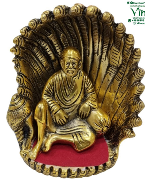 Shell Sai Baba, seated figure before a large fanned scallop shell on a red base