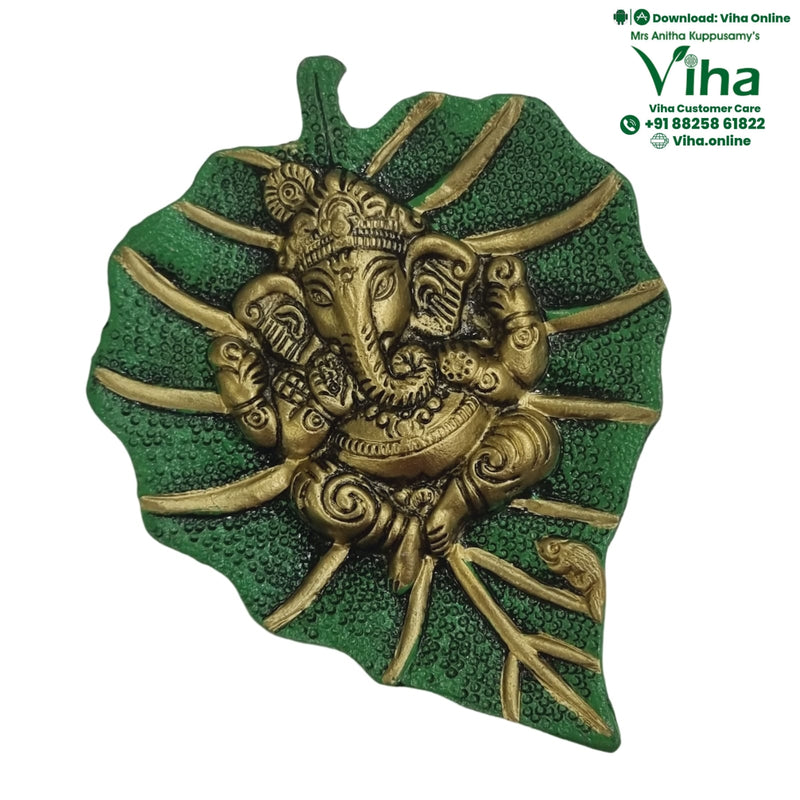 Green Leaf Ganesha Wall Hanger, a green-textured leaf sculpture featuring an elephant-headed figure in gold-toned finish with multiple radiating stems