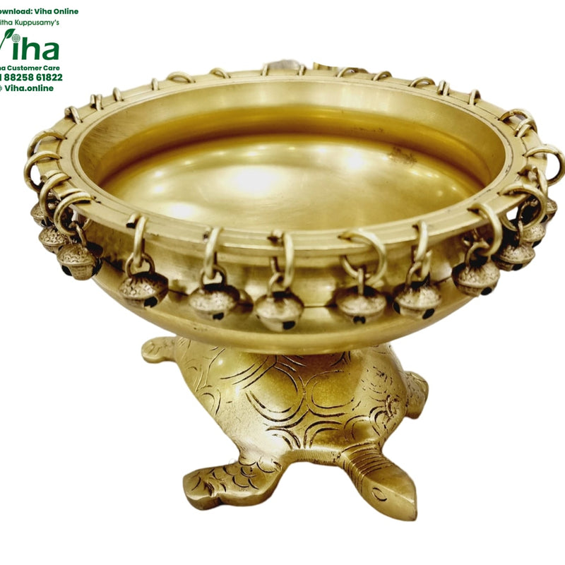 Tortoise Urli, brass bowl with small bells hanging from rings around the rim, on a tortoise-shaped base with engraved shell