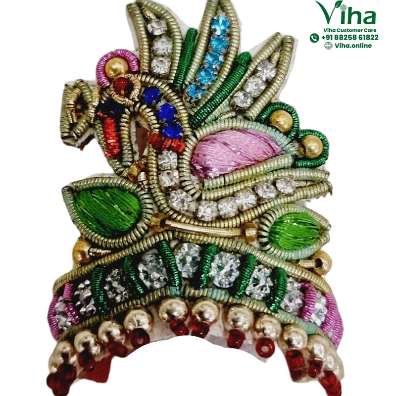 Idol Mukut, an ornate embroidered patch with gold-toned wires, clear stones, green leaves, pink fabric, and dangling beads