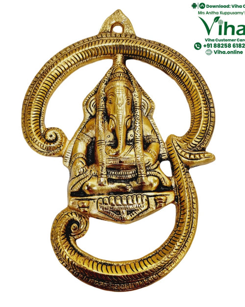 Ganesha "OM" Wall Hanging, a gold-toned metal wall hanging features a seated figure inside a circular frame with scrolled elements