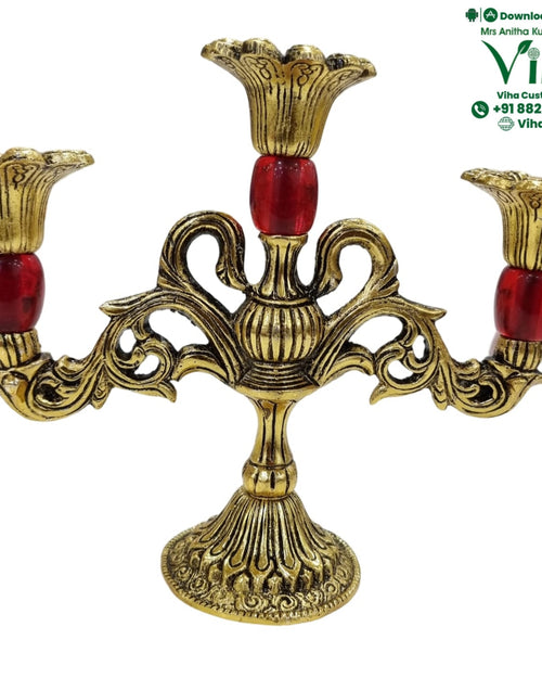 Antique brass candle stand, three fluted candle cups on scrolled arms with red stone accents