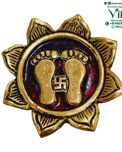 Mahalakshmi Charan Padhuka, a gold-toned and red round plaque with eight petals, featuring two gold-toned footprints and a central symbol