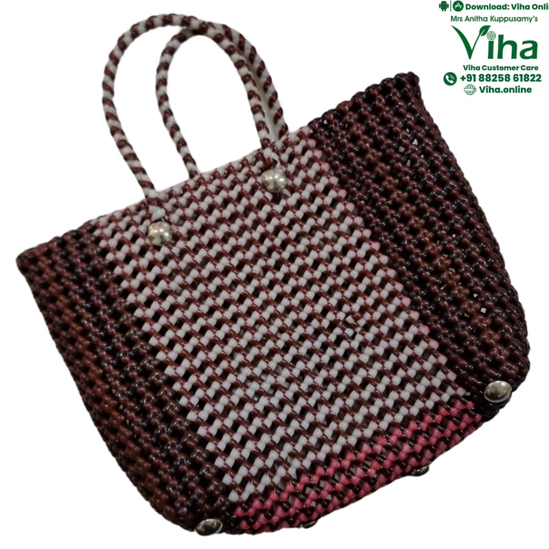 Wire Koodai, a woven tote bag features a brown, white, and pink checkered pattern, two arched handles, and three silver-toned feet on the base