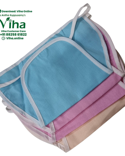 Baby Langott Pure Cotton, a stacked pile of three folded fabric items in blue, pink, and beige with white-edged curved flaps and straps