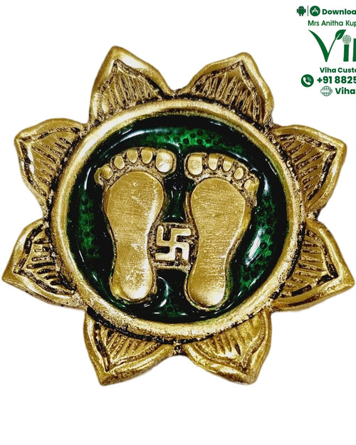 Mahalakshmi Charan Padhuka, a gold-toned metal medallion with eight lotus petals, a green center, and two feet with a swastika between them