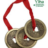 Fengsui Coin, three brass-toned round metal coins with square center holes and embossed Chinese characters threaded on a red ribbon