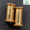 Impon Thali Nanal Kuzhai - Small, two glossy gold-toned spool-shaped cylinders with flanged ends standing upright against a dark grey textured background