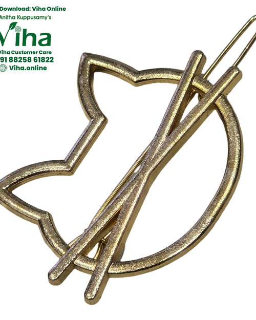 Hair Clip, a gold-toned metallic cat-shaped frame with two diagonal bars crossing the circular right section and a clasp pin extending upward from the top