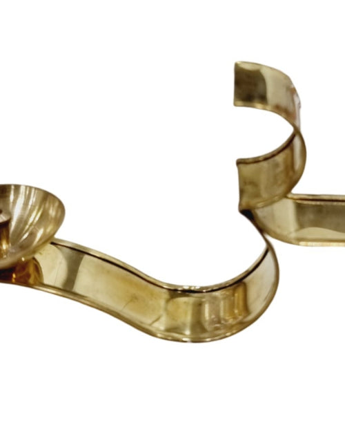 Om athma deepam, flat brass ribbon shaped into an Om with a small oil cup at one end