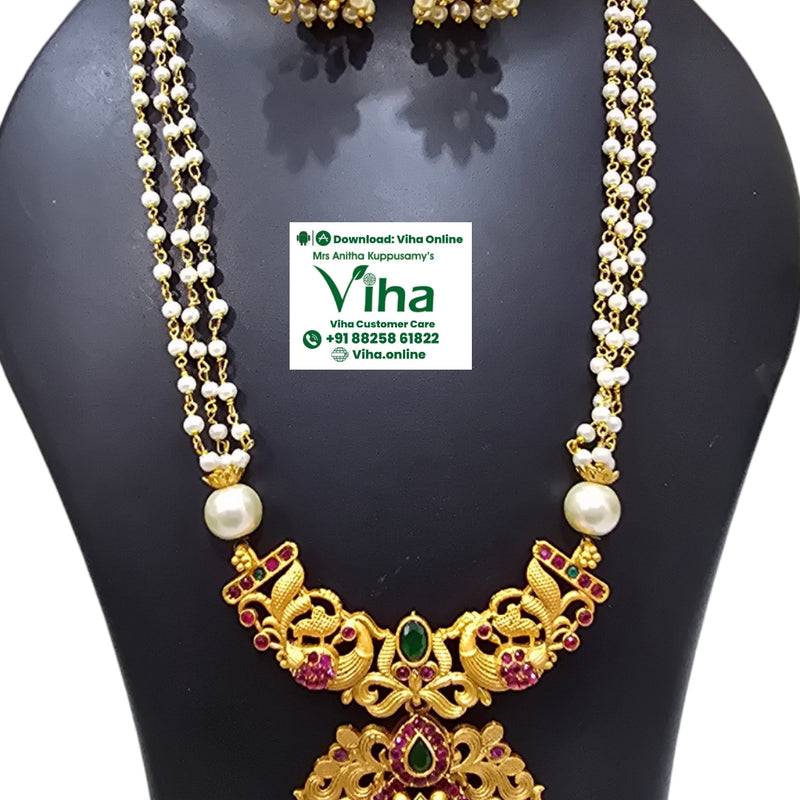White Beads Chain Set, a gold-toned jewelry set with white beads, red and green stones, featuring a three-strand necklace and matching jhumka earrings