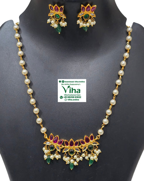 White Beads Lotus Pendant Chain Set, a gold-toned jewelry set with white beads, red, green and clear stones against a black background