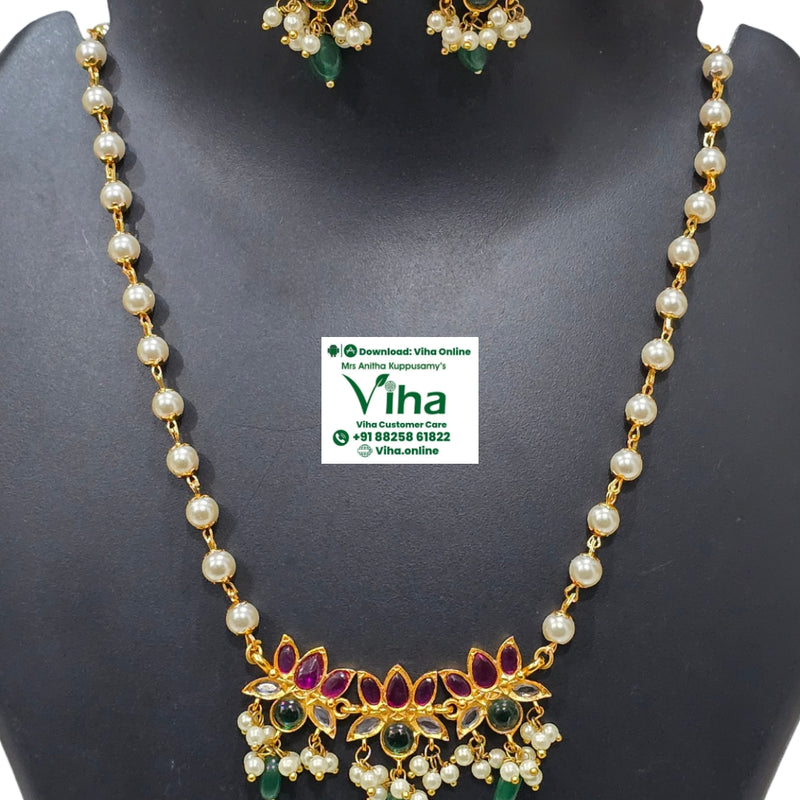 White Beads Lotus Pendant Chain Set, a gold-toned jewelry set with white beads, red, green and clear stones against a black background
