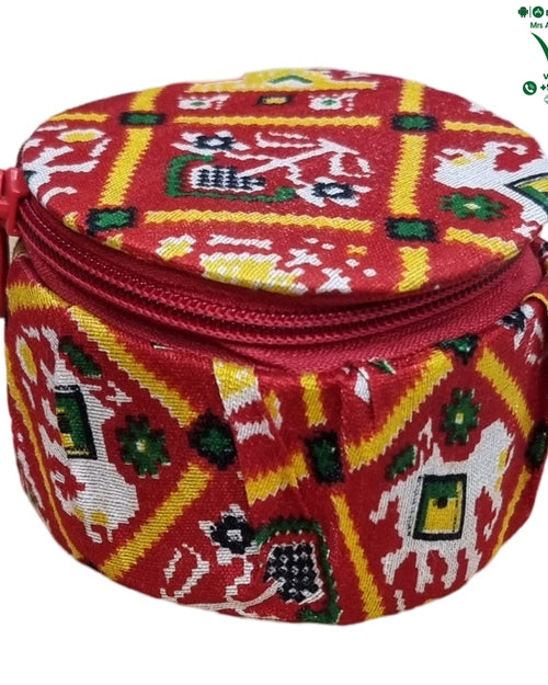 Storage Box, a small, round red zippered pouch features a patterned fabric cover in red, yellow, white, and green with geometric and animal motifs