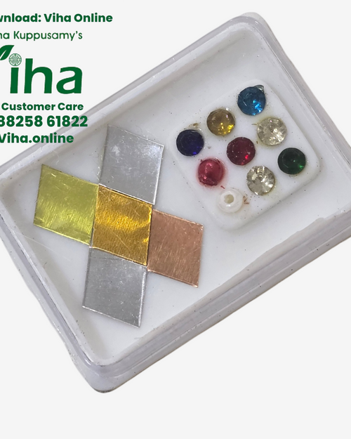 Vastu Panchaloha Set, a white plastic box containing four metallic squares and ten assorted colorful stones arranged on a white insert
