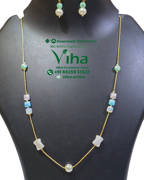 Trendy Chain Set, a gold-toned chain necklace with multicolored beads and matching drop earrings on a black display bust