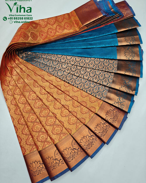 Semi Silk Saree, an array of folded textiles in bronze-toned, blue, and coral featuring intricate floral and paisley patterns with wide metallic borders