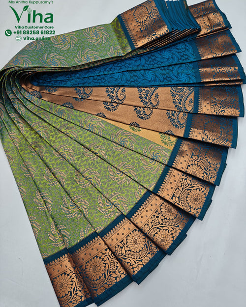 Semi Silk Saree, folded fabric featuring green, teal, and copper-toned sections with intricate leaf and floral patterns and a wide border
