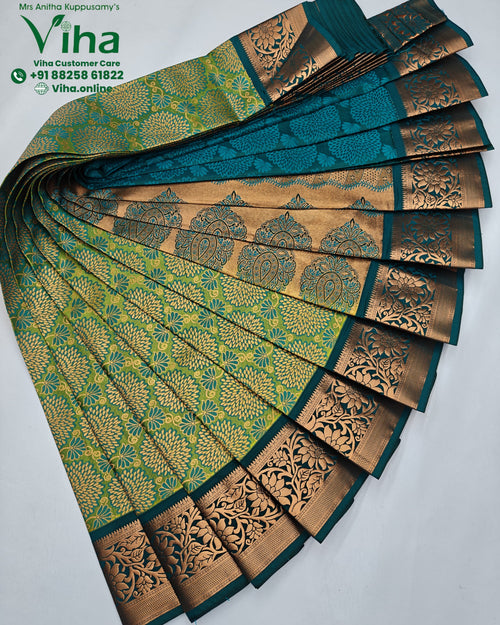 Silk Saree, a fan-shaped fold of green and teal fabric features glossy gold-toned woven floral patterns and ornate borders with botanical motifs